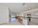 Bright kitchen featuring stainless steel appliances, granite counters, an island with seating, and sliding glass doors to the yard at 1504 Colt Creek Pl, Wesley Chapel, FL 33543