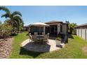 Outdoor patio with dining table and chairs surrounded by landscaped yard at 16331 Treasure Point Dr, Wimauma, FL 33598