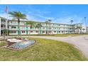 Low angle shot of updated condo building with turquoise railings and doors with meticulous landscaping at 1900 59Th N Ave # 217, St Petersburg, FL 33714