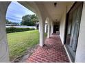 Charming patio area with red brick flooring, arched columns and view of yard at 2114 Indian N Ave, Belleair Bluffs, FL 33770