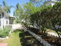 Beautiful backyard with lush greenery, trees and a stone retaining wall at 21537 Clubside Loop, Lutz, FL 33549