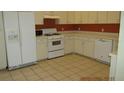 Functional kitchen with white cabinets, appliances, and tile flooring at 21537 Clubside Loop, Lutz, FL 33549