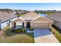 Inviting one-story house featuring a cozy front yard with pretty landscaping and a two car garage at 2812 Gumbo Limbo Dr, Wimauma, FL 33598