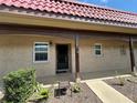 Welcoming condo exterior highlighting the red terracotta tile roof, covered entryway, and manicured plants at 601 N Hercules Ave # 403, Clearwater, FL 33765