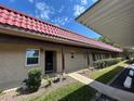 Inviting condo showcasing a terracotta roof, covered porch, and well-kept front yard landscaping at 601 N Hercules Ave # 403, Clearwater, FL 33765