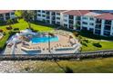Aerial view of a waterfront community pool with many lounge chairs and sun umbrellas at 6265 Sun Blvd # 806, St Petersburg, FL 33715