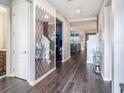 Inviting entryway features stylish wood floors, a decorative mirror, and a view into the living spaces at 7494 Pool Compass Loop, Wesley Chapel, FL 33545