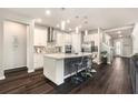 Modern kitchen features white cabinetry, stainless steel appliances, an island with a breakfast bar, and pendant lighting at 7494 Pool Compass Loop, Wesley Chapel, FL 33545