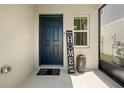 Inviting entryway featuring a stylish black door and decorative welcome sign at 7580 Freesia Trce, Wesley Chapel, FL 33545