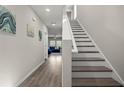Hallway featuring hardwood floors, stairs, and decoratively painted walls at 7580 Freesia Trce, Wesley Chapel, FL 33545