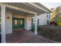 Elegant double front door entrance with brick paving, well-lit sconces, and lush shrubs at 7922 Spring Valley Dr, Tampa, FL 33615