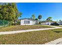 Well-maintained single-story home with a neat front lawn and a spacious carport area at 8003 W Powhatan Ave, Tampa, FL 33615