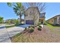 Charming two-story home with a well-manicured lawn, mature trees, and a two-car garage at 8306 Red Spruce Ave, Riverview, FL 33578
