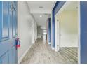 Long hallway with wood-look tile flooring and contrasting blue and gray walls at 1571 Montgomery Bell Rd, Wesley Chapel, FL 33543