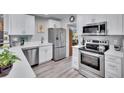 Modern kitchen with stainless steel appliances, white cabinets, and quartz countertops at 1623 San Mateo Dr, Dunedin, FL 34698