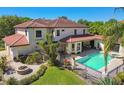 Beautiful backyard with a pool, fire pit, patio, lush greenery, and a terracotta tile roof on the house at 17003 Madres De Avila, Tampa, FL 33613