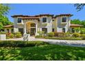 Elegant home with a red tile roof, cream-colored stucco, manicured lawn, and columns at the entryway at 17003 Madres De Avila, Tampa, FL 33613