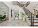 Grand foyer with marble floors, staircase with iron railings, and views of the backyard and living spaces at 17003 Madres De Avila, Tampa, FL 33613