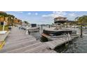 View of the community dock with multiple boats and nearby buildings under a partly cloudy sky at 1720 Mariner Way, Tarpon Springs, FL 34689