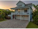 Charming two-story coastal home featuring a spacious balcony, three-car garage, and beautiful paver driveway at 1720 Mariner Way, Tarpon Springs, FL 34689