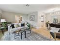 Open-concept living room with contemporary decor, stylish seating, and seamless flow to the dining area at 1870 Wateroak W Dr, Clearwater, FL 33764