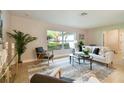 Bright living room with large windows, stylish furniture, and a neutral color palette at 1870 Wateroak W Dr, Clearwater, FL 33764