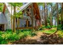 Home with exposed wooden beams, front porch, and lush, tropical landscaping at 20926 Ragan Ln, Land O Lakes, FL 34638