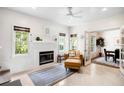 Bright living room featuring a fireplace, a comfortable armchair, and french doors that lead to the dining room at 2217 Brevard Ne Rd, St Petersburg, FL 33704