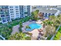 Aerial view of a community pool with lounge chairs and tropical landscaping at 400 Island Way # 1708, Clearwater Beach, FL 33767