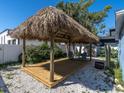 Outdoor living space featuring a wooden Tiki hut with chairs and a gravel base at 4500 23Rd S Ave, St Petersburg, FL 33711
