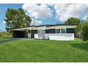 Charming single-story home with black and white accent paint and a lush green lawn at 5108 Tangelo Dr, New Port Richey, FL 34652