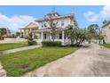 Two-story home featuring a well-manicured lawn, a water fountain, and lush palm trees at 5426 Venetian Ne Blvd, St Petersburg, FL 33703
