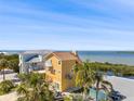 Multi-story home featuring a balcony and palm trees, with a beautiful waterfront view on a sunny day at 6633 Driftwood Dr, Hudson, FL 34667