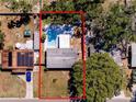 Overhead view of the property, defined by red lines, featuring the pool, backyard, house, and surrounding landscape at 8829 93Rd St, Seminole, FL 33777