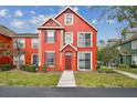 Charming red two-story townhome with manicured lawn and inviting curb appeal in a well-maintained community at 9118 Lake Chase Island Way # 9118, Tampa, FL 33626
