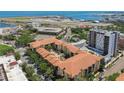 Stunning aerial view of the condo complex with a red tile roof, resort-style pool, and lush greenery, near the bay and airport at 100 4Th S Ave # 220, St Petersburg, FL 33701