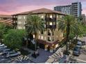 Condo building featuring a tile roof, balconies, and mature palm trees in a sunny setting at 100 4Th S Ave # 220, St Petersburg, FL 33701