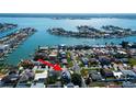 Gorgeous elevated aerial view home nestled waterfront community with stunning water views and lush landscaping at 103 Morgan Dr, Belleair Beach, FL 33786
