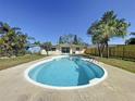 Backyard view of a kidney-shaped pool surrounded by a well-maintained patio and lush landscaping at 10754 63Rd Ave, Seminole, FL 33772