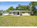 Inviting one-story home boasts a covered front porch and lush green lawn in a desirable neighborhood at 1231 27Th S Ave, St Petersburg, FL 33705