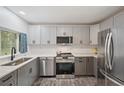 This modern kitchen features stainless steel appliances, grey cabinets, and sleek countertops at 13102 Wagner Dr, Hudson, FL 34667