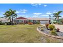 Charming single-story home with well-manicured lawn, mature palm trees, and beautiful landscaping at 1804 Bunker Hill Dr, Sun City Center, FL 33573