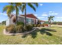 Lush landscaping and mature palm trees accent this inviting single-story home at 1804 Bunker Hill Dr, Sun City Center, FL 33573