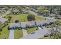 Aerial view of townhomes, manicured lawns, and mature trees in a quiet community at 18836 Summersong Dr, Hudson, FL 34667