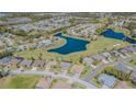 Aerial view of homes nestled around a scenic lake and golf course in a vibrant community at 18836 Summersong Dr, Hudson, FL 34667