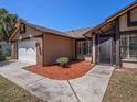 Inviting front entrance with a decorative flower pot, walkway, and charming brick and siding facade at 2412 Arborwood Dr, Valrico, FL 33596