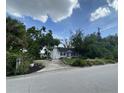 Charming home with a brick walkway, bright red front door and lush landscaping at 3204 W Clinton St, Tampa, FL 33614