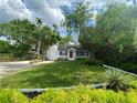 Charming home with a brick walkway, bright red front door and lush landscaping at 3204 W Clinton St, Tampa, FL 33614