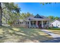 Charming home with inviting front porch, manicured lawn, and mature trees, offering a serene curb appeal at 37410 Dixie Ave, Dade City, FL 33525