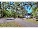Two-car garage with ample parking space, set amongst mature trees and lush greenery for a private, country-living feel at 37410 Dixie Ave, Dade City, FL 33525